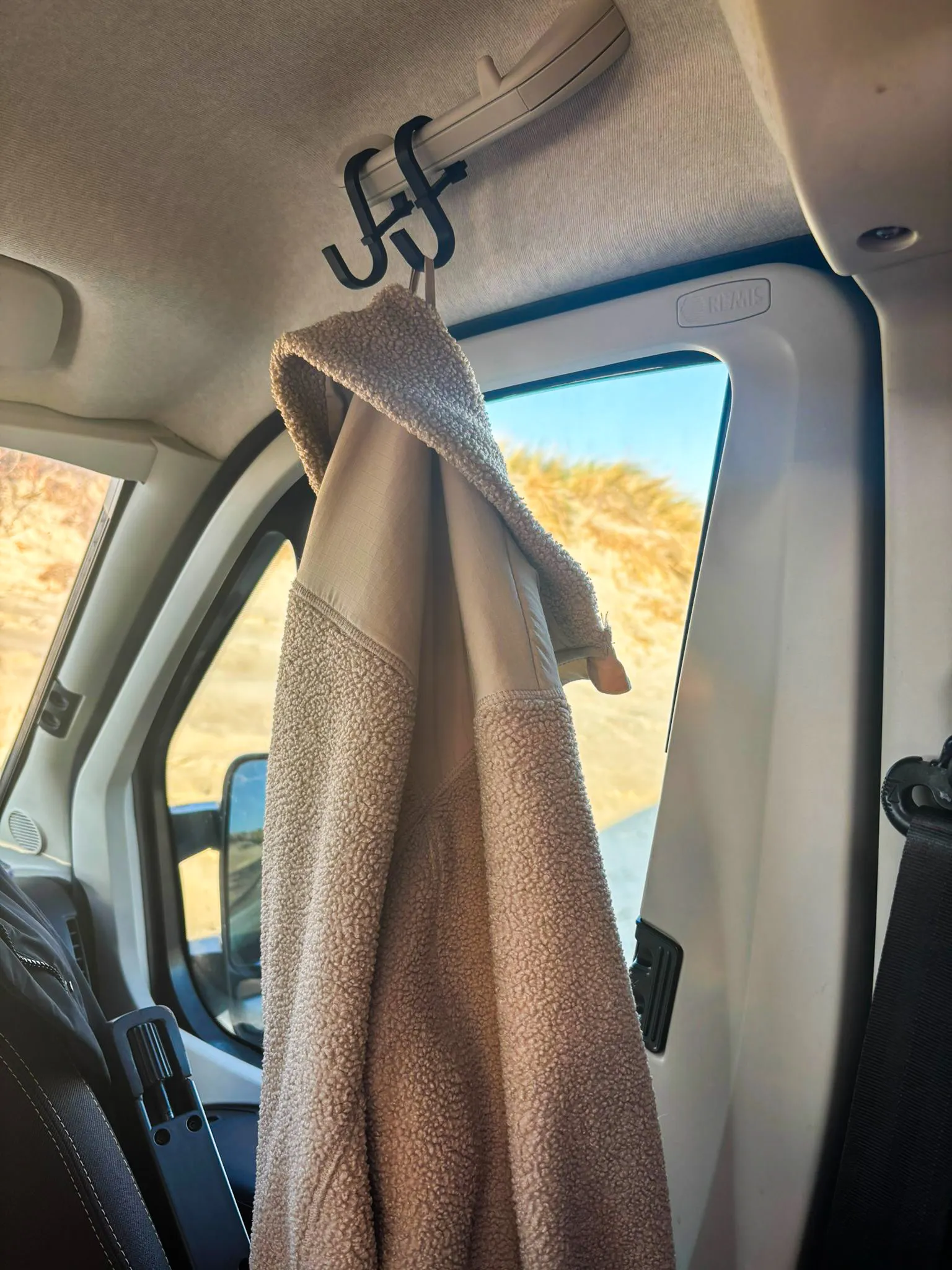 Jacke hängt ordentlich im Camper am Haltegriff