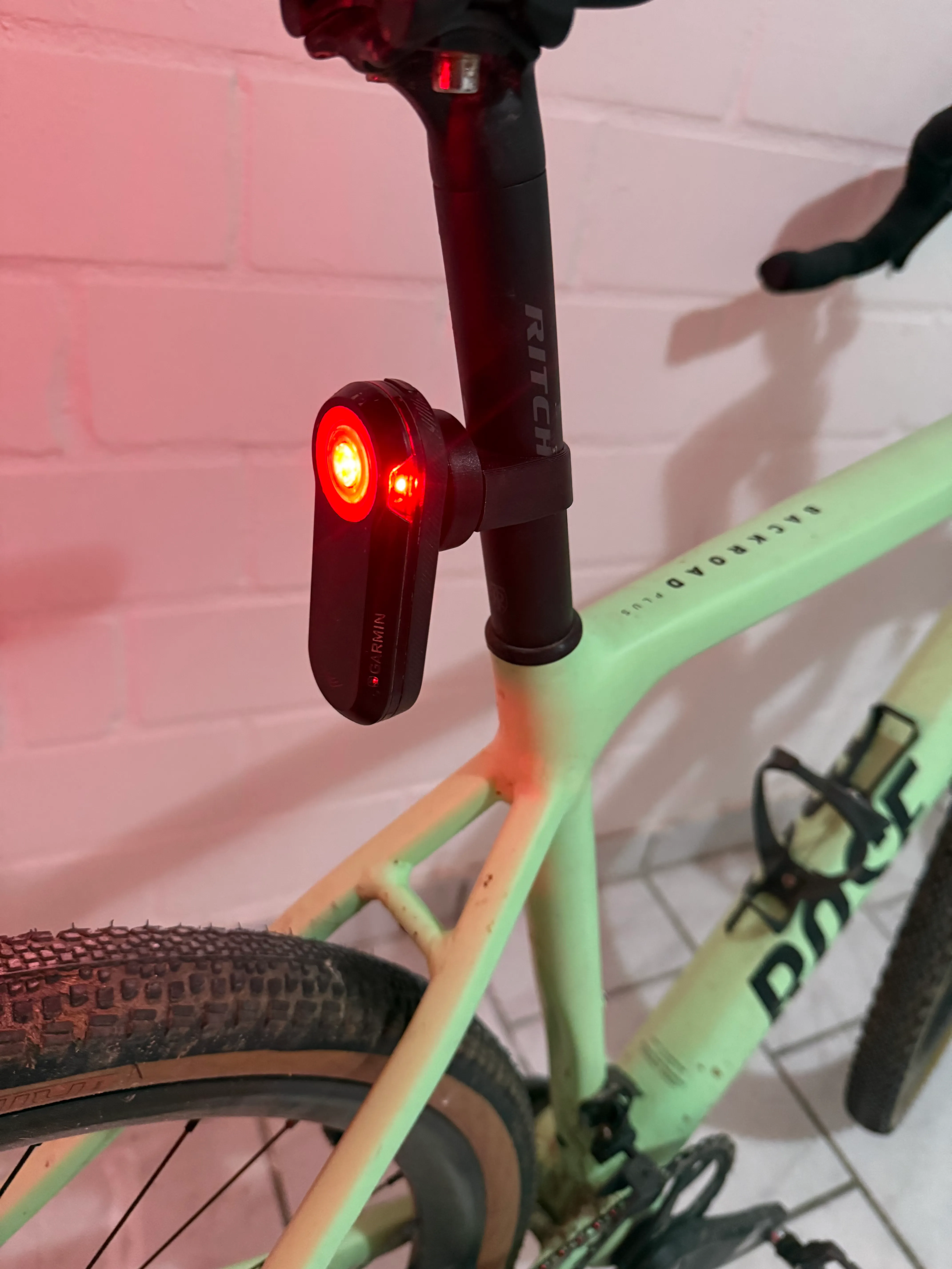 Eingeschaltetes Garmin Varia Rücklicht im Halter an der runden Sattelstütze eines Gravelbikes